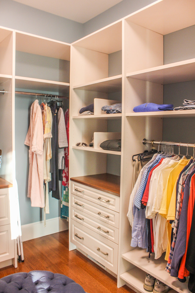 Foto de armario vestidor unisex tradicional grande con armarios con paneles con relieve, puertas de armario blancas y suelo de madera en tonos medios