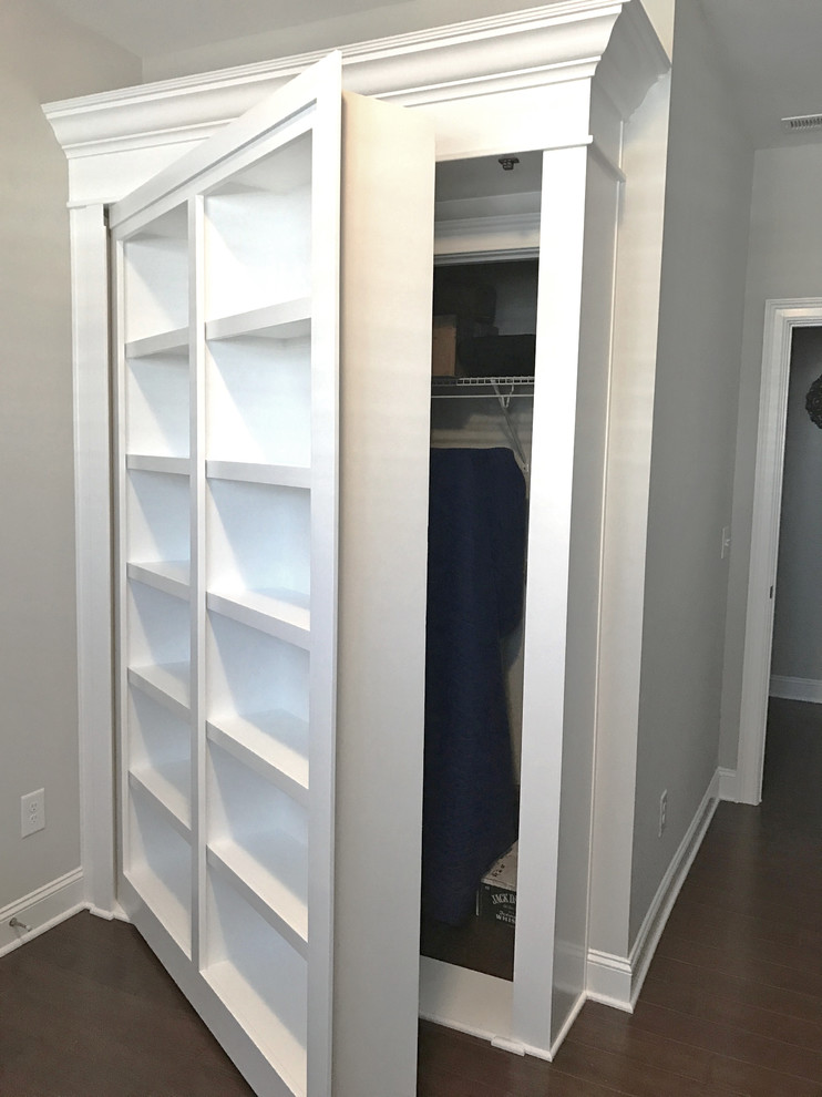 Diseño de armario de tamaño medio con puertas de armario blancas y suelo de madera en tonos medios