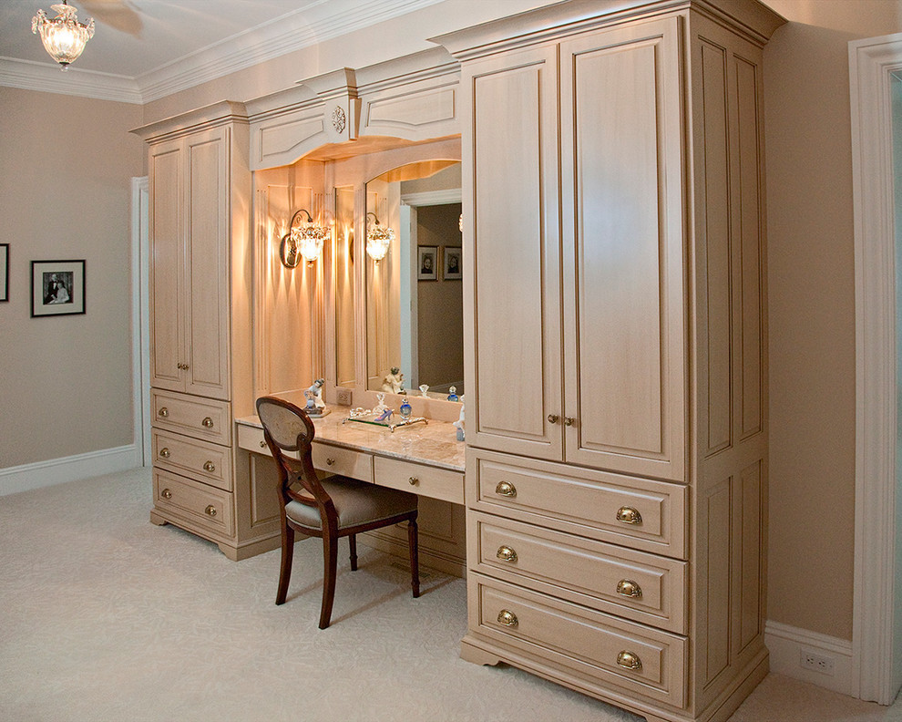 Idées déco pour un grand dressing room classique en bois clair pour une femme avec un placard avec porte à panneau surélevé, moquette et un sol beige.