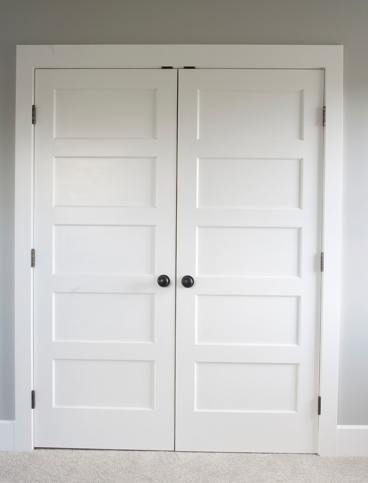 На фото: шкаф в нише унисекс в стиле кантри с ковровым покрытием и бежевым полом с