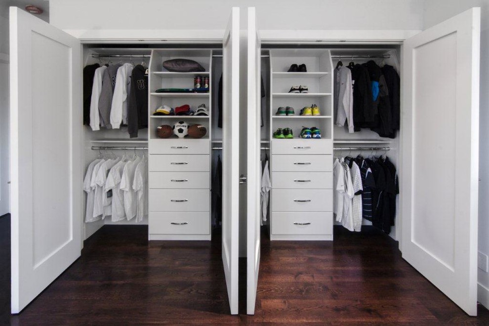 Modelo de armario unisex tradicional de tamaño medio con armarios con paneles lisos, puertas de armario blancas y suelo de madera en tonos medios