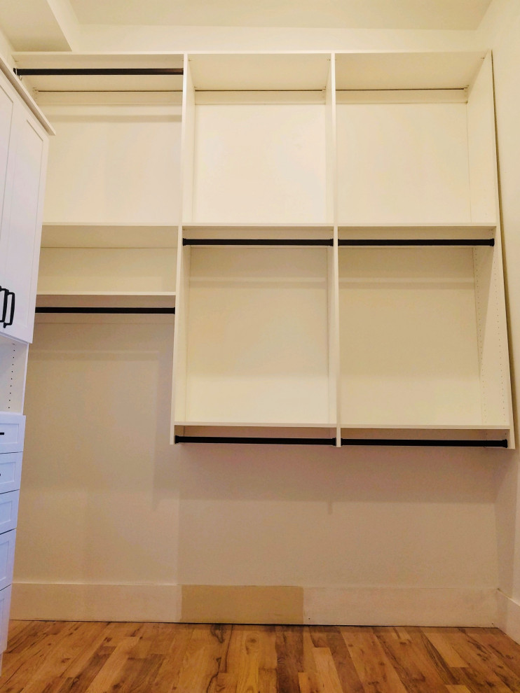 This is an example of a large contemporary built-in wardrobe in Other with raised-panel cabinets.