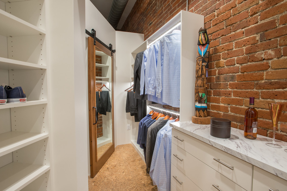 Industriell inredning av ett walk-in-closet för könsneutrala, med öppna hyllor, vita skåp, korkgolv och beiget golv