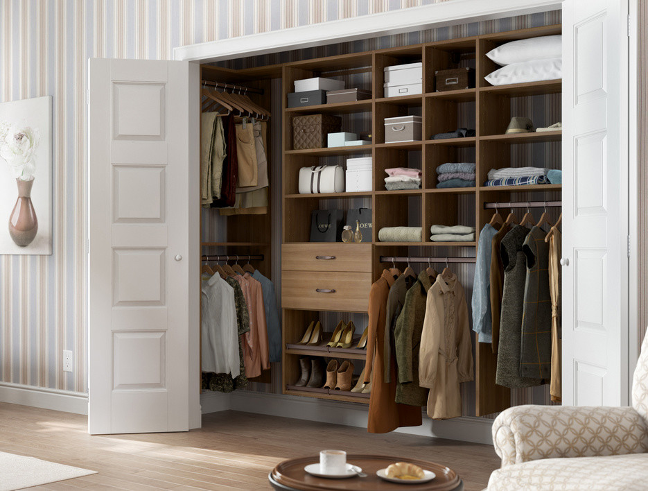 Design ideas for a small contemporary gender neutral standard wardrobe in Nashville with open cabinets, medium wood cabinets and light hardwood flooring.