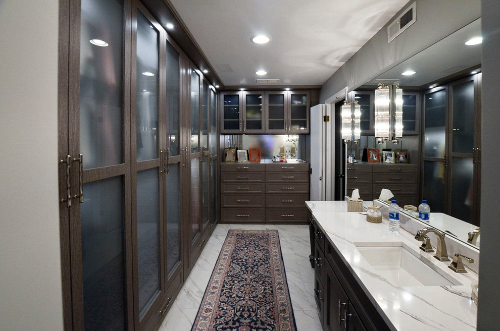 Cette photo montre un grand dressing room en bois foncé neutre avec un placard à porte vitrée, un sol en marbre et un sol blanc.