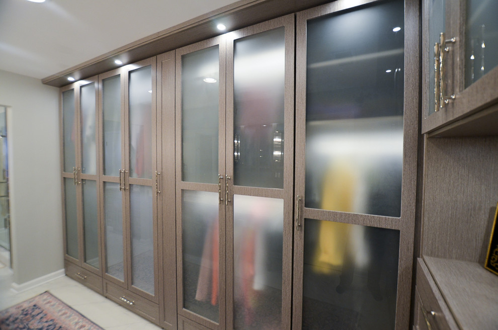 Esempio di un grande spazio per vestirsi unisex con ante di vetro, ante in legno bruno, pavimento in marmo e pavimento bianco
