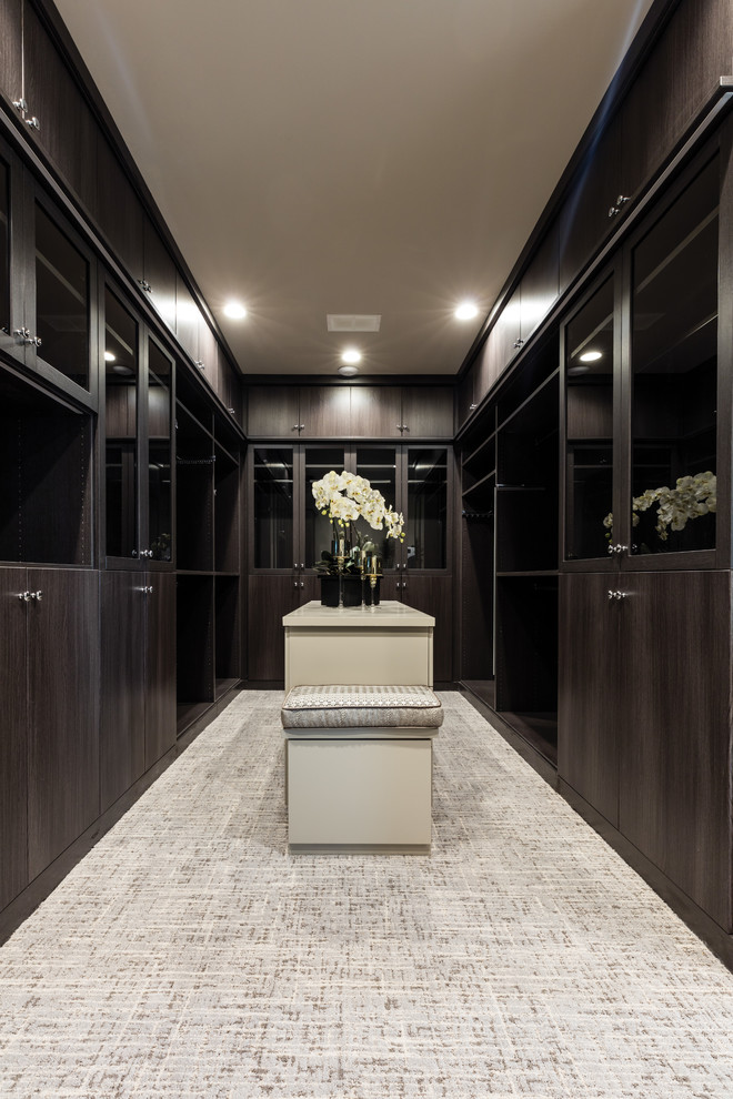 Aménagement d'un très grand dressing room classique en bois foncé avec un placard à porte plane, moquette et un sol gris.