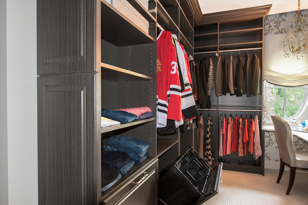 Ejemplo de armario vestidor unisex tradicional renovado grande con armarios con paneles con relieve, puertas de armario de madera oscura y moqueta