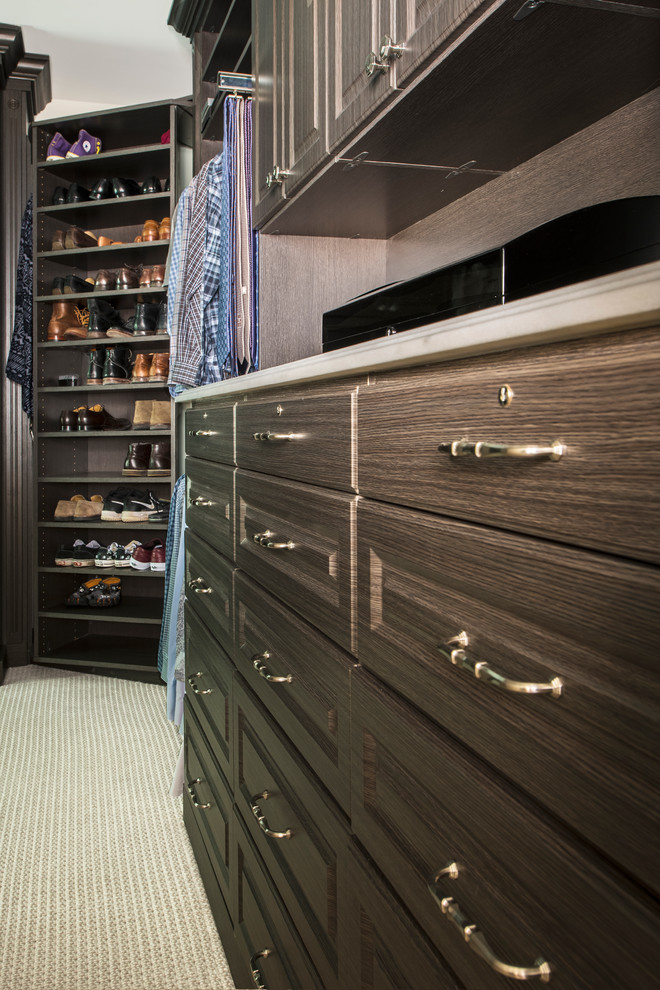 Imagen de armario vestidor unisex tradicional renovado grande con armarios con paneles con relieve, puertas de armario de madera oscura y moqueta