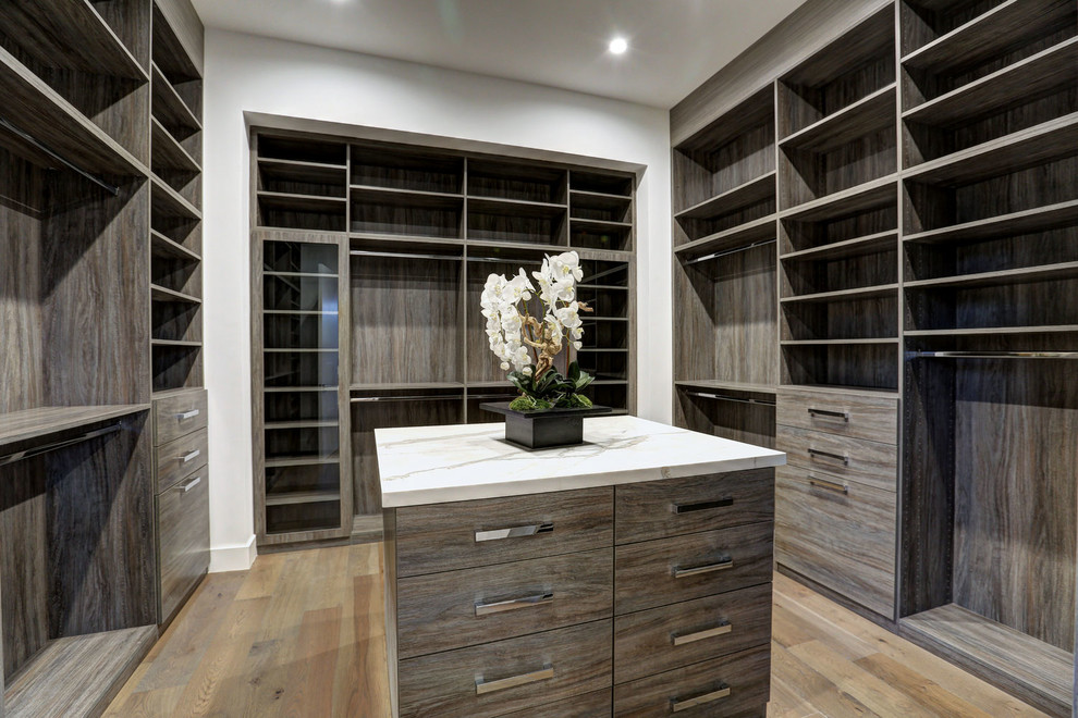 Inspiration for a large modern gender neutral walk-in wardrobe in Los Angeles with flat-panel cabinets, light wood cabinets, light hardwood flooring and brown floors.