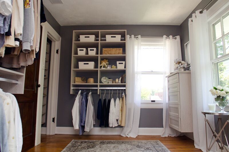 Imagen de vestidor de mujer clásico de tamaño medio con suelo de madera en tonos medios, armarios abiertos y puertas de armario blancas
