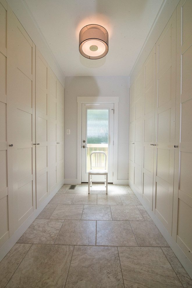 Idée de décoration pour un dressing room champêtre avec un placard à porte shaker, des portes de placard blanches et un sol en carrelage de céramique.