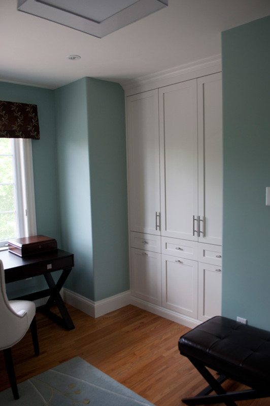 Imagen de armario y vestidor tradicional renovado con armarios estilo shaker, puertas de armario blancas y suelo de madera clara