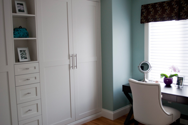 Classic dressing room in Other with shaker cabinets, white cabinets and light hardwood flooring.