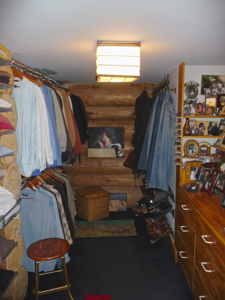 Ejemplo de vestidor de hombre rústico de tamaño medio con armarios con paneles lisos, puertas de armario de madera oscura y moqueta