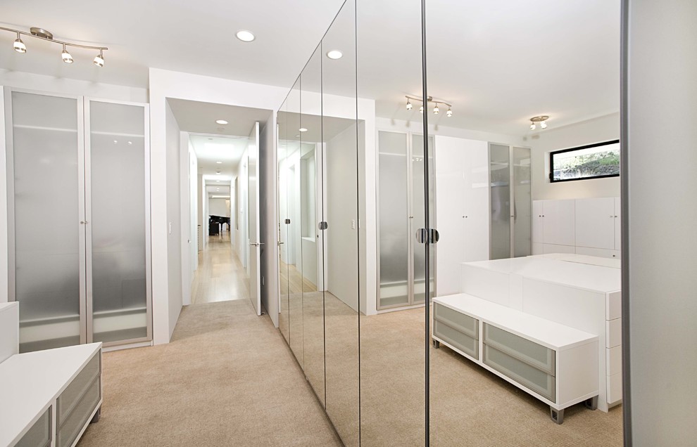 Inspiration for a contemporary dressing room in San Francisco with white cabinets, carpet and feature lighting.
