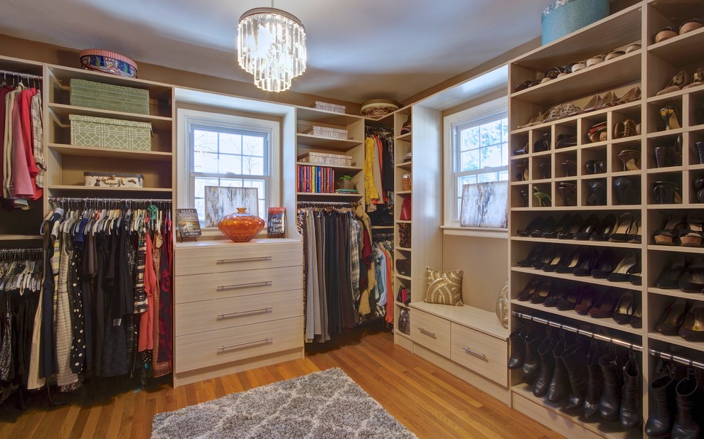 Modelo de armario vestidor de mujer minimalista grande con armarios con paneles lisos, puertas de armario de madera clara y suelo de madera clara