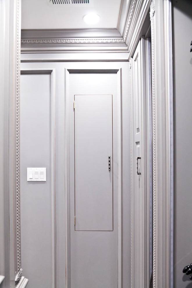 Immagine di una cabina armadio unisex chic di medie dimensioni con ante con bugna sagomata, ante marroni e moquette