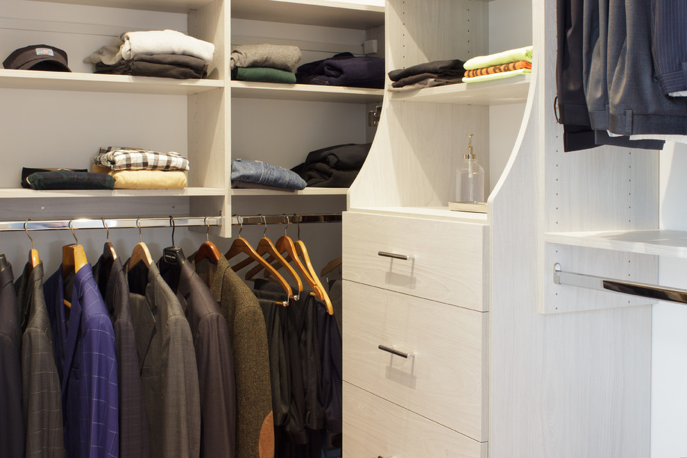 Modelo de armario vestidor de hombre contemporáneo pequeño con armarios con paneles lisos, puertas de armario de madera clara y suelo de madera clara