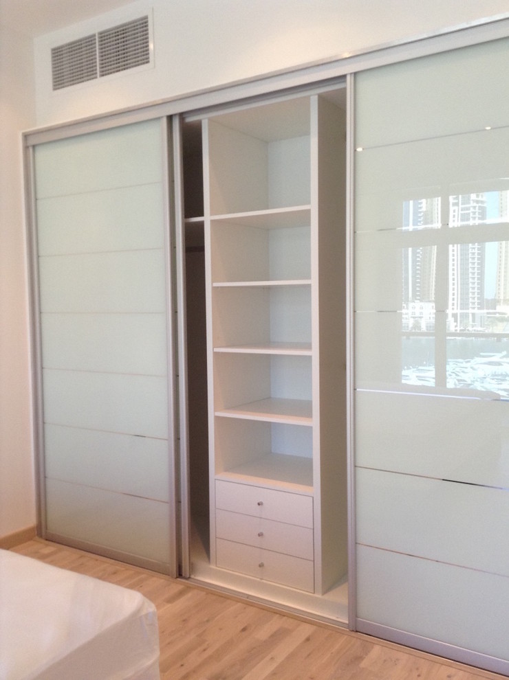 Foto de armario unisex moderno de tamaño medio con armarios tipo vitrina, puertas de armario blancas, suelo beige y suelo de madera en tonos medios