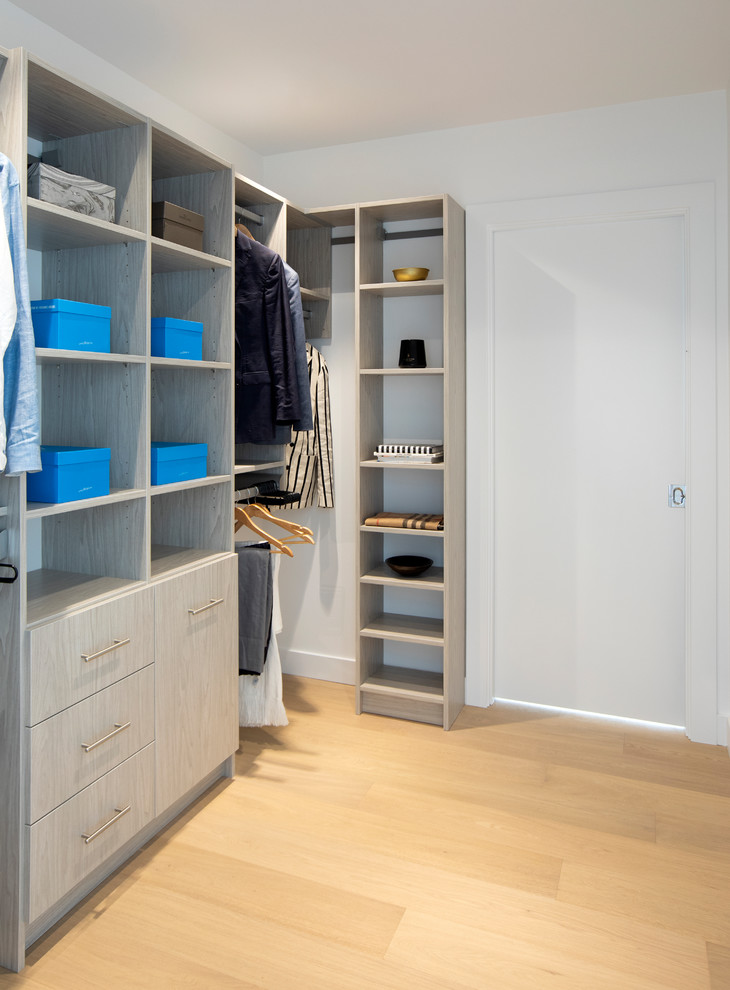 Medium sized modern walk-in wardrobe for men in Vancouver with flat-panel cabinets, light wood cabinets, light hardwood flooring and beige floors.