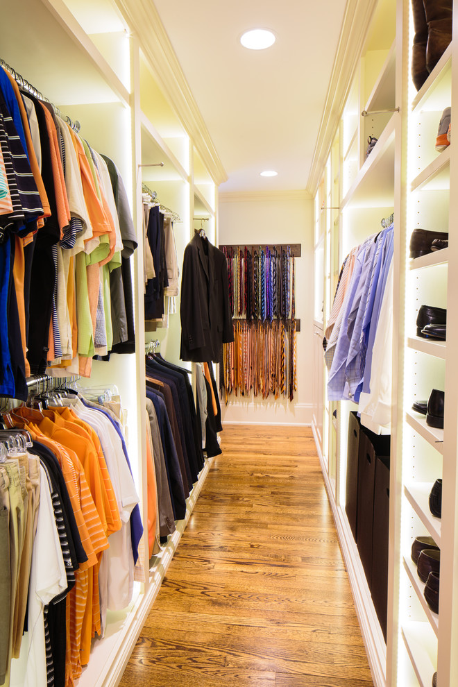Elegant men's medium tone wood floor walk-in closet photo in Other with open cabinets and white cabinets