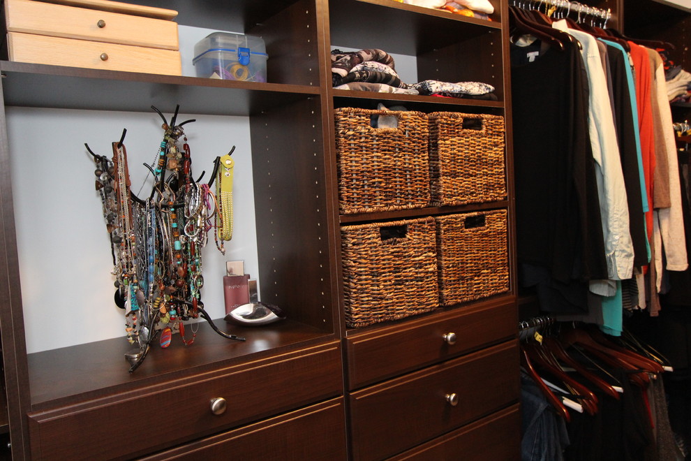 Ejemplo de armario vestidor unisex clásico de tamaño medio con armarios con paneles con relieve, puertas de armario de madera oscura y moqueta