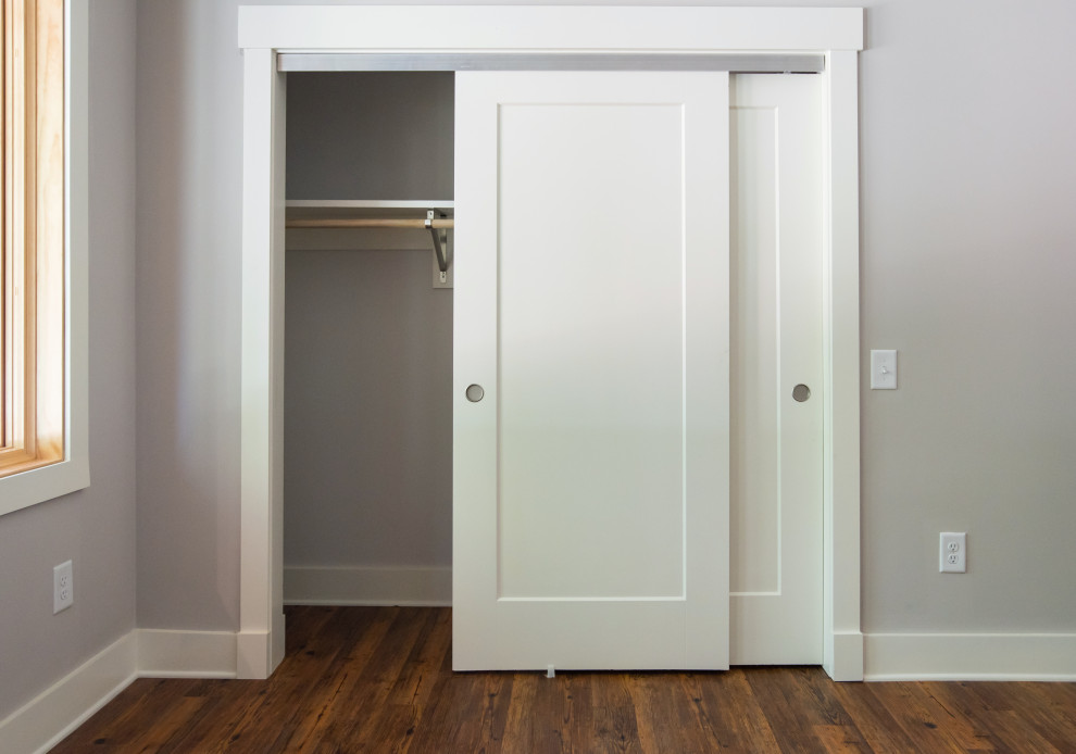 Immagine di un armadio o armadio a muro unisex classico di medie dimensioni con pavimento in laminato e pavimento marrone