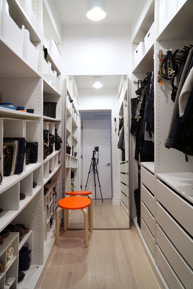 Ispirazione per una cabina armadio per donna minimalista di medie dimensioni con ante lisce, ante bianche e parquet chiaro