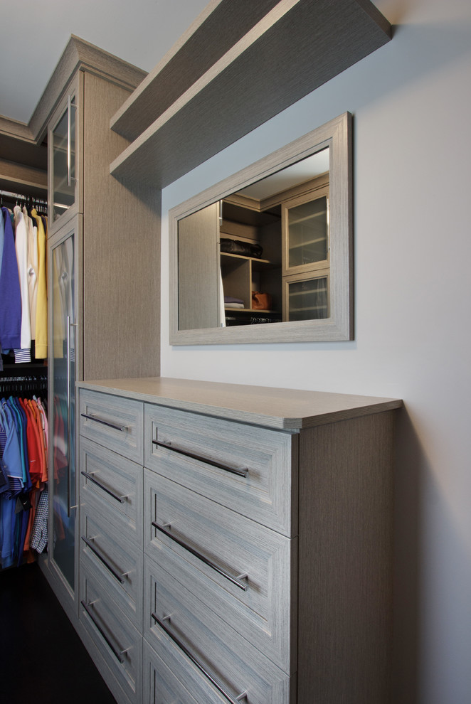 Ejemplo de armario vestidor unisex tradicional renovado pequeño con armarios con paneles empotrados, puertas de armario grises y suelo de madera oscura