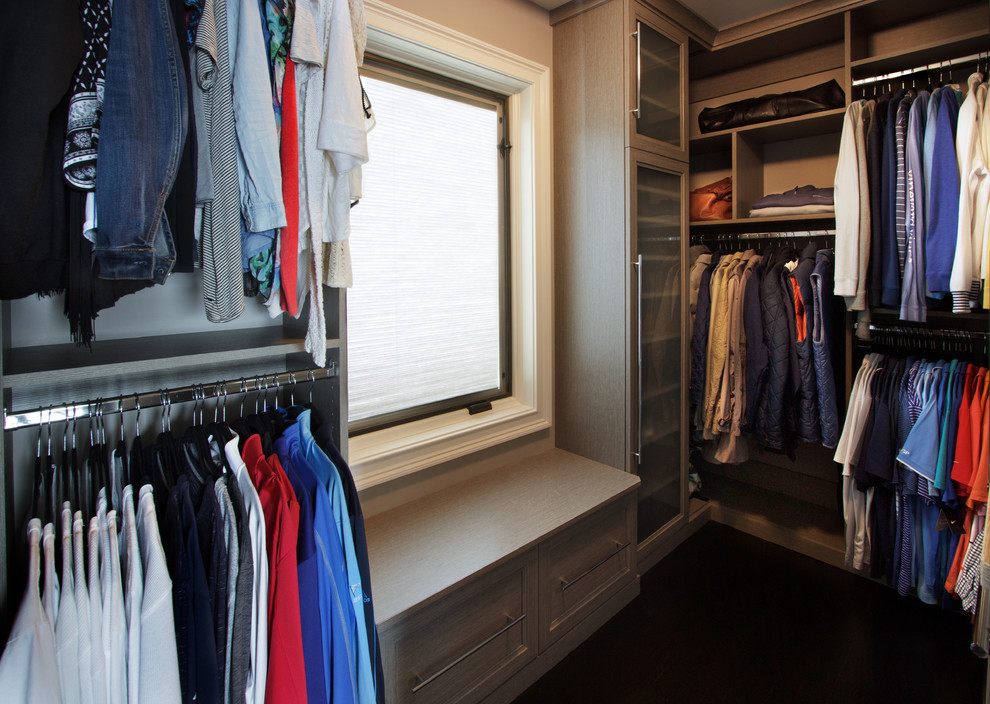 Ejemplo de armario vestidor unisex clásico renovado pequeño con armarios con paneles empotrados, puertas de armario grises y suelo de madera oscura