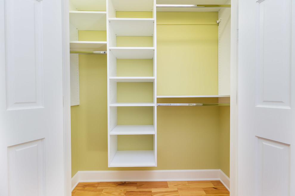 Ejemplo de armario unisex tradicional renovado de tamaño medio con armarios abiertos, puertas de armario blancas y suelo de madera en tonos medios