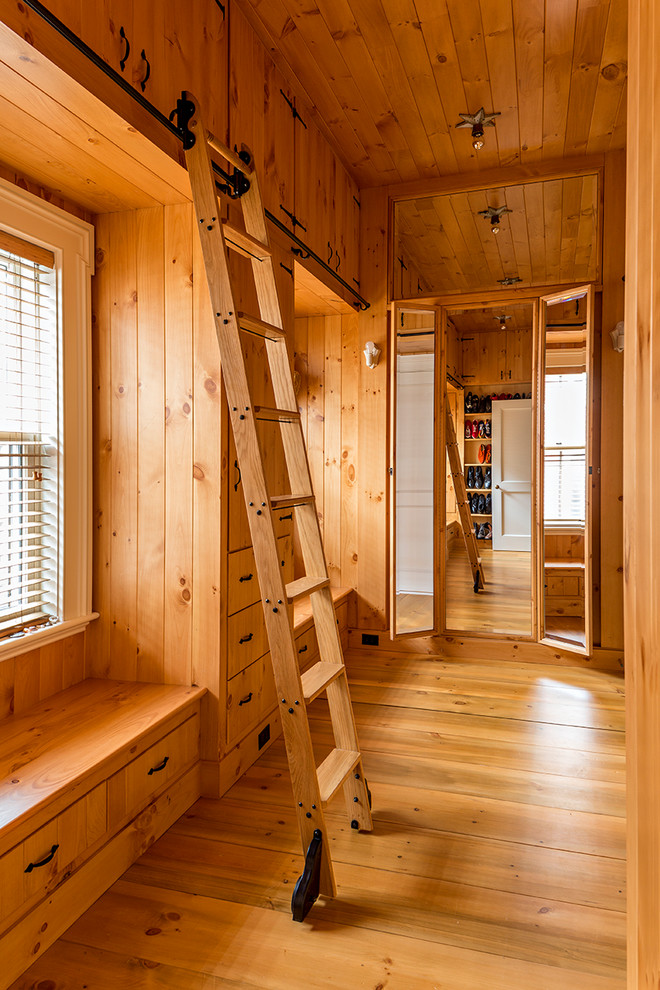 Ispirazione per una grande cabina armadio unisex tradizionale con ante in legno scuro e pavimento in legno massello medio