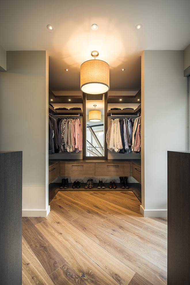 Mid-sized trendy men's medium tone wood floor dressing room photo in Vancouver with flat-panel cabinets and dark wood cabinets