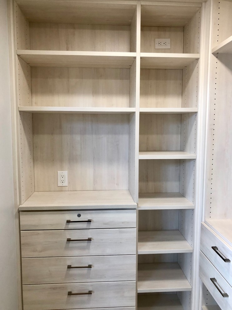 Photo of a medium sized contemporary walk-in wardrobe for women in Denver with flat-panel cabinets, beige cabinets, light hardwood flooring and grey floors.