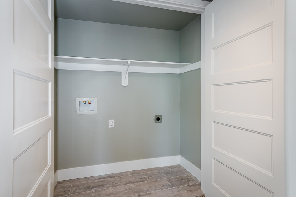 Immagine di un piccolo armadio o armadio a muro unisex design con pavimento in laminato e pavimento marrone