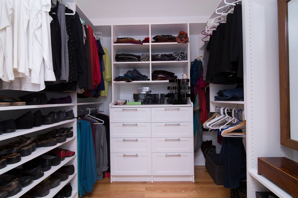 Modelo de armario vestidor unisex tradicional renovado de tamaño medio con armarios estilo shaker, puertas de armario blancas, suelo de madera en tonos medios y suelo naranja