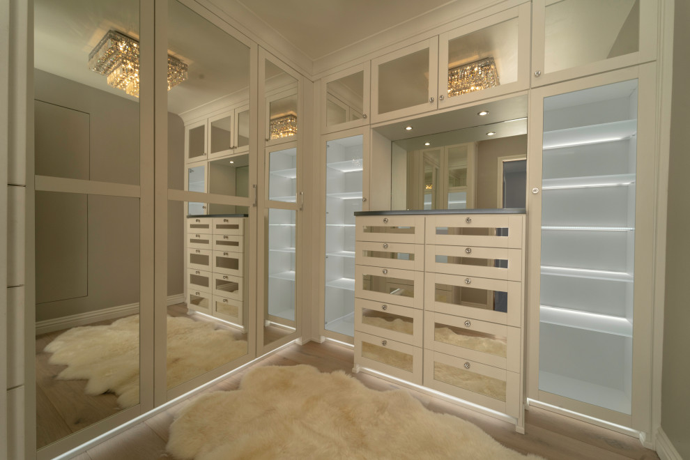 Идея дизайна: гардеробная комната среднего размера в современном стиле с стеклянными фасадами, белыми фасадами, паркетным полом среднего тона и коричневым полом для женщин