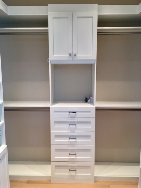 Diseño de armario vestidor unisex clásico de tamaño medio con armarios estilo shaker, puertas de armario blancas y suelo de madera clara
