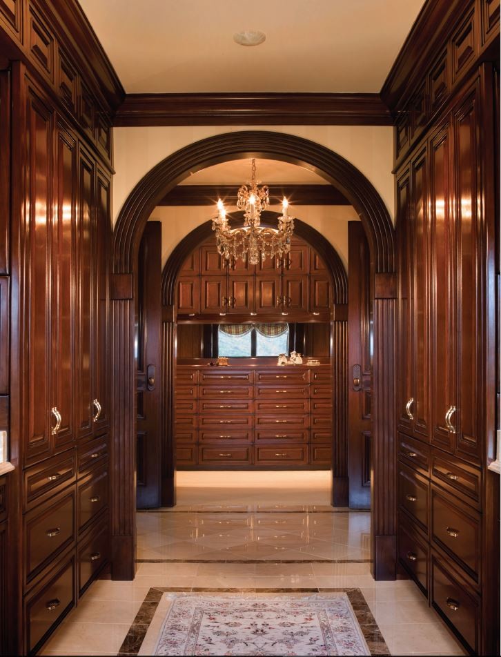 Idée de décoration pour un très grand dressing room tradition en bois foncé neutre avec un placard avec porte à panneau surélevé.