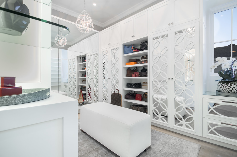 Inspiration for a large classic dressing room for women in Los Angeles with white cabinets and grey floors.