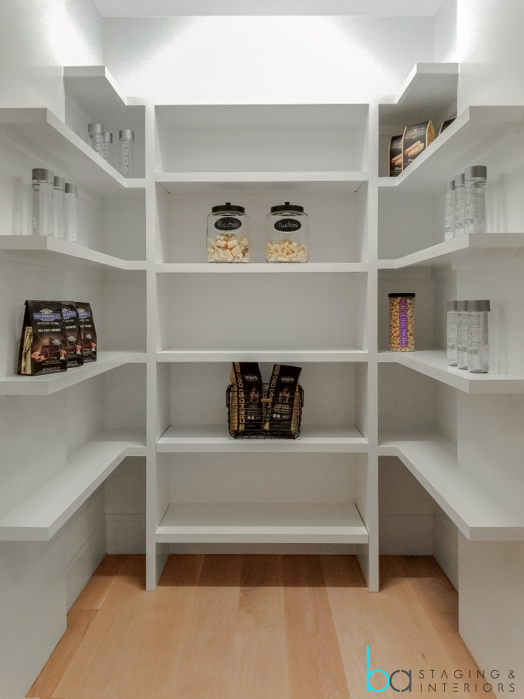 Inspiration for a large contemporary light wood floor and beige floor walk-in closet remodel in New York