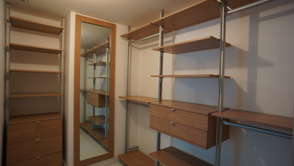 Ejemplo de armario vestidor unisex contemporáneo de tamaño medio con armarios abiertos, puertas de armario de madera oscura y suelo de baldosas de porcelana