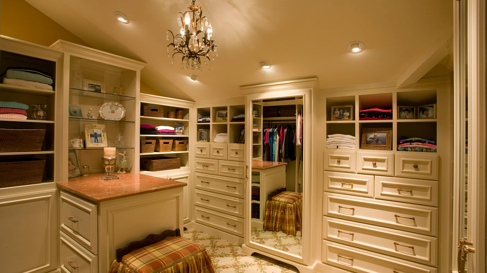This is an example of a classic dressing room for women in Nashville with beige cabinets and carpet.