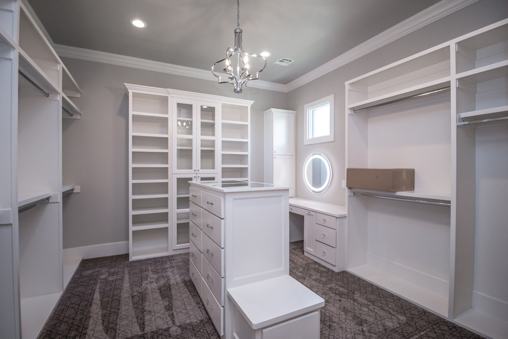 Inspiration for a large traditional gender neutral walk-in wardrobe in Other with flat-panel cabinets, white cabinets, carpet and grey floors.