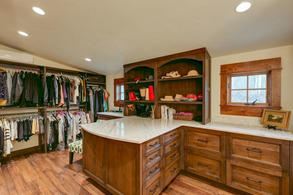 This is an example of an expansive rustic gender neutral dressing room in Denver with recessed-panel cabinets, medium wood cabinets, medium hardwood flooring and brown floors.