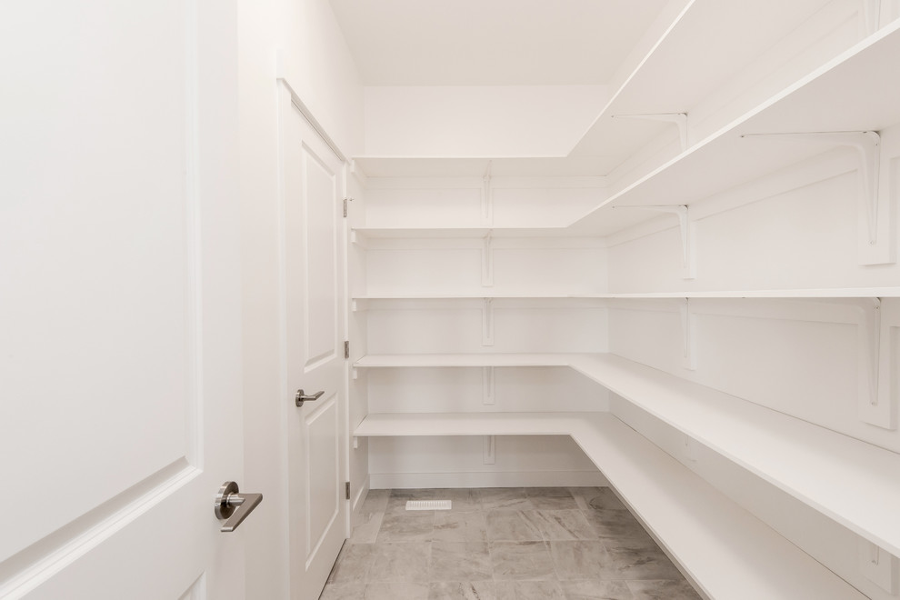 Immagine di una cabina armadio unisex design di medie dimensioni con pavimento con piastrelle in ceramica, nessun'anta, ante bianche e pavimento beige