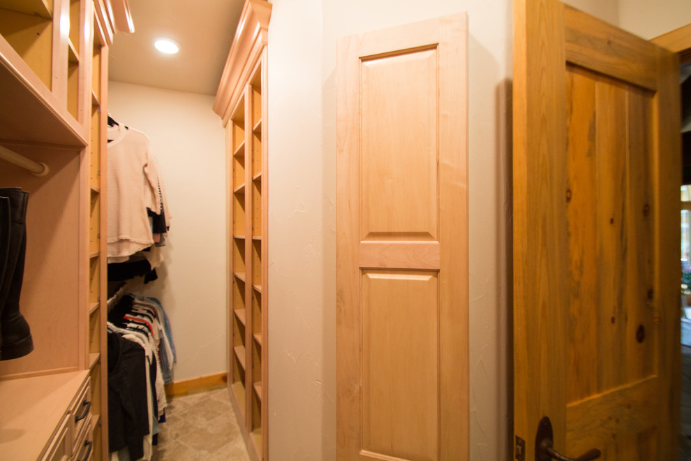 Photo of a large classic gender neutral walk-in wardrobe in Denver with raised-panel cabinets, light wood cabinets, travertine flooring and beige floors.