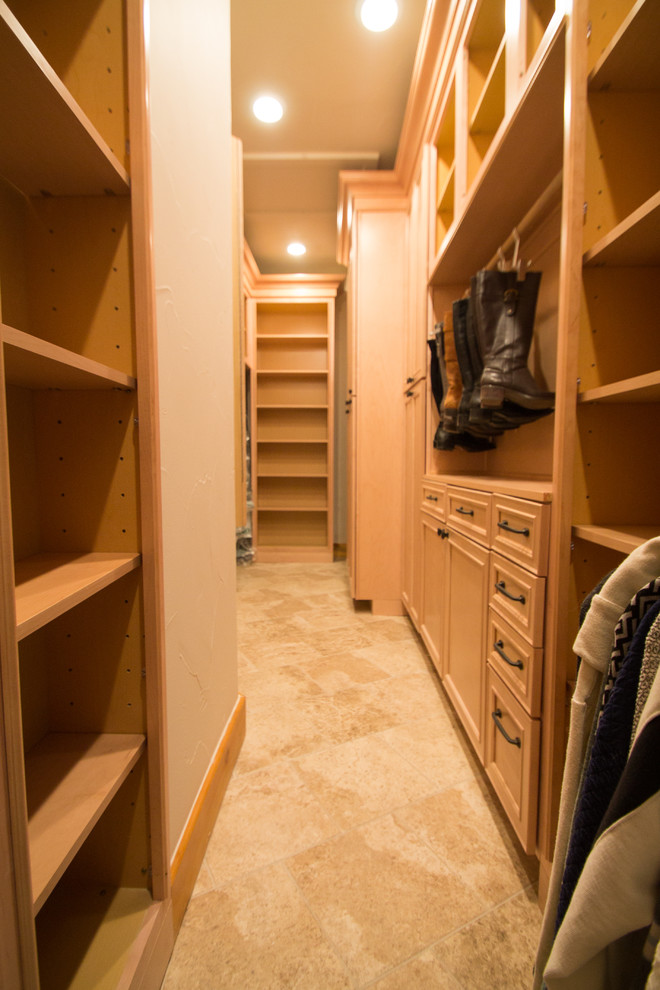 Design ideas for a large traditional gender neutral walk-in wardrobe in Denver with raised-panel cabinets, light wood cabinets, travertine flooring and beige floors.