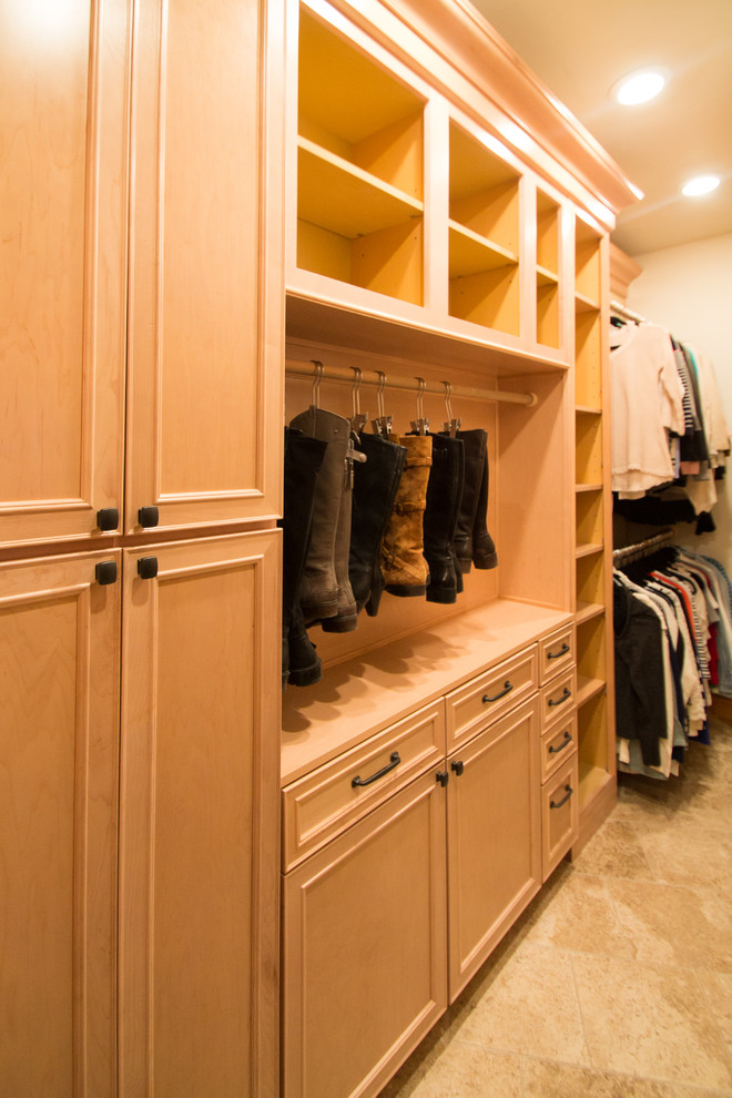 Photo of a large traditional gender neutral walk-in wardrobe in Denver with raised-panel cabinets, light wood cabinets, travertine flooring and beige floors.